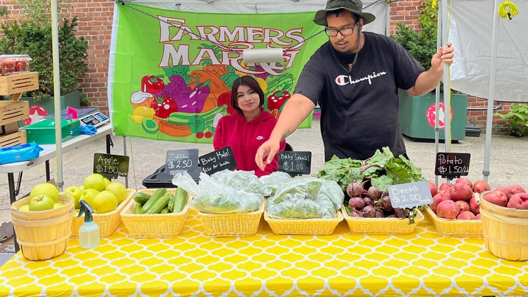Two young people operating a farmers market in Hunts Point.