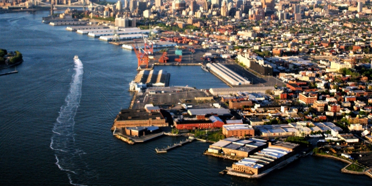 Aerial view of Brooklyn waterfront with Red Hook in foreground and East river in background.